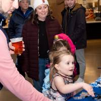 Young girl spinning prize wheel at merch table